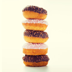 close up of glazed donuts pile over white