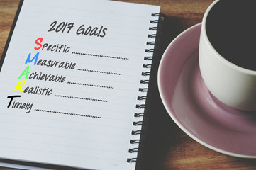 SMART goals for 2017 on notepad with cup of coffee, retro style background.