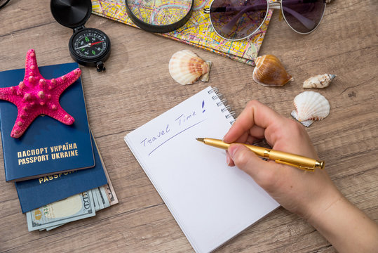 woman write in blank notepad with travel tools