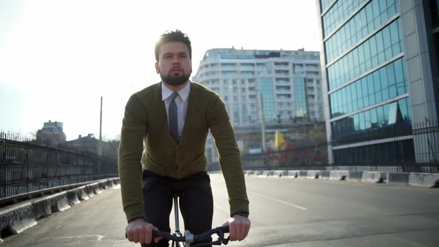 handsome man rides a bicycle in the empty street slow motion
