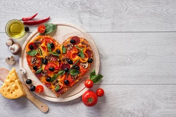 Photo sur Plexiglas Pizzeria Savoureuse pizza en forme de coeur décorée de légumes et d& 39 herbes sur fond de bois blanc. Produit haute résolution.