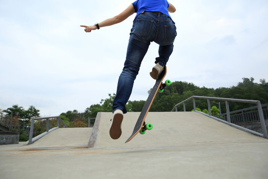 young woman skateboarder skateboarding at skate park