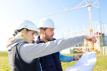 Two workers working outside on a construction site