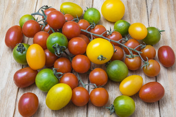 red, yellow and green tomatoes on a wooden table
