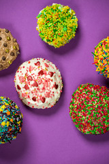 Multicolored cupcakes on purple table