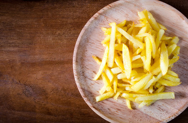 French fries on wood dish on wooden background
