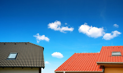 Roof house with tiled roof on blue sky.