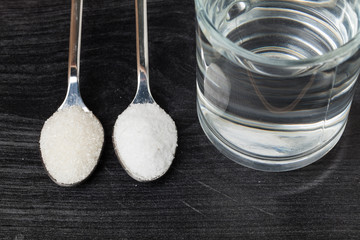 Spoon of salt, sugar, soda with glass of water