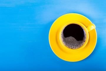 Cup of coffee on blue wooden table. Toned
