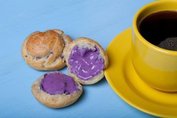 Fresh homemade profiteroles and cup of coffee on blue wooden tab