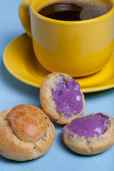 Fresh homemade profiteroles and cup of coffee on blue wooden tab