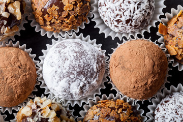 Round homemade chocolates in different kind of decor on paper su