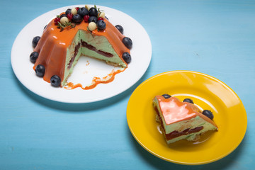 Orange mousse cake with berries n the blue wooden table
