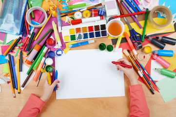 Child drawing top view. Artwork workplace with creative accessories. Flat lay art tools for...