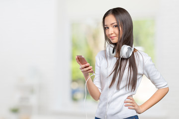 Beautiful young Asian woman wearing a set of headphones