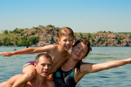 Dad Mom And Son Swimming In The River