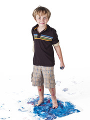 portrait of a elementary boy making imprints on piece of paper.