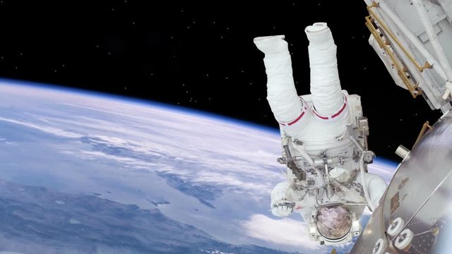 Astronaut Working On International Space Station. Upside down. Elements of this image furnished by NASA