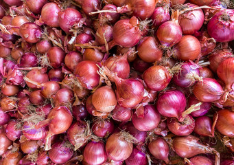 Heap of red onions on market