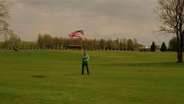 Man waving American flag on a glade