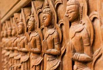 Poster Bouddha Carved wooden sculpture of praying Buddha in a line of different prayers
