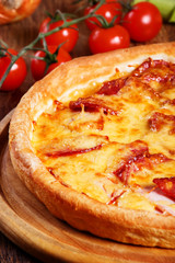 Pizza with salami, pastrami, ham and cheese on wooden table