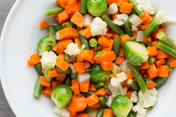 Fresh vegetables mix in a white bowl.
