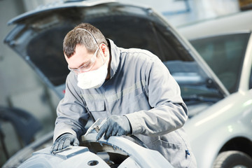 auto repairman grinding autobody bonnet 