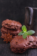 Chocolate meringue cookies with nuts on a black background