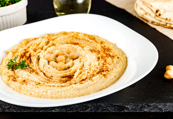 Hummus with pita on black stone plate