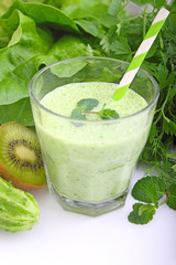 A glass of smoothie with green vegetables and spinach