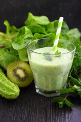 A glass of smoothie with green vegetables and spinach