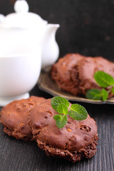 Chocolate meringue cookies with nuts on a black background