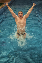 A young man jumps in the pool