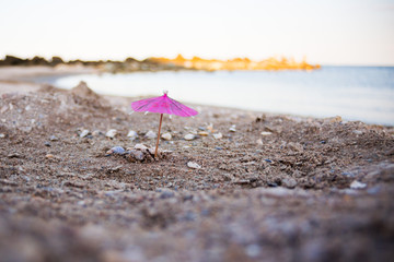 Fototapeta na wymiar miniature with cocktail umbrella on the beach