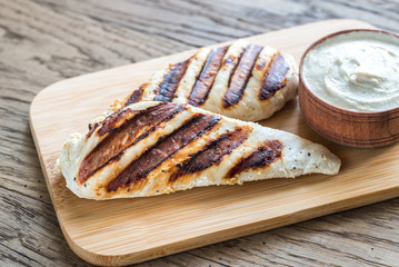 Grilled chicken with tahini sauce on the wooden board
