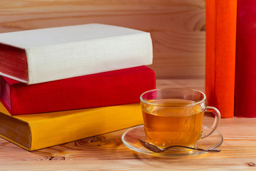 Cup of tea and books onwooden background