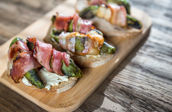 Toasts with cream cheese and avocado wrapped in bacon