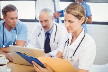 Female doctor looking at medical report