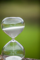 Modern hourglass on green background with Vignetting effect. symbol of time. sandglass.