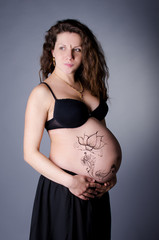 Pregnant girl with henna tattoo on her belly