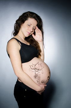 Pregnant girl with henna tattoo on her belly