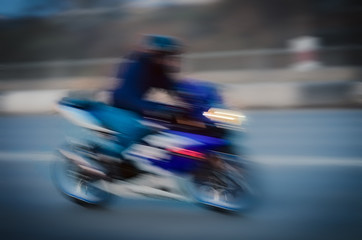 Fototapeta premium Blurred background with fast running motorcyclist