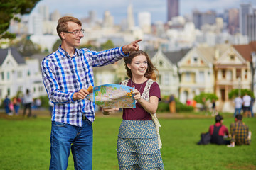 Romantic couple of tourists using map in San Francisco, California, USA