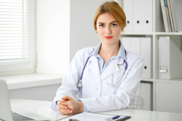 Female doctor sitting at the desk near window