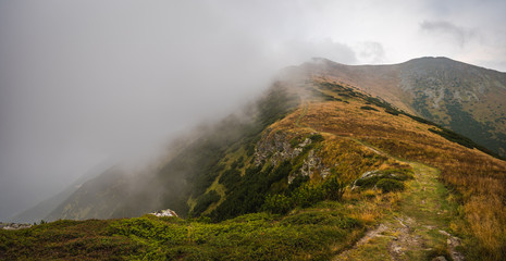 Hiking Trail on the Hill with Fog in the Mountains on Overcast Day