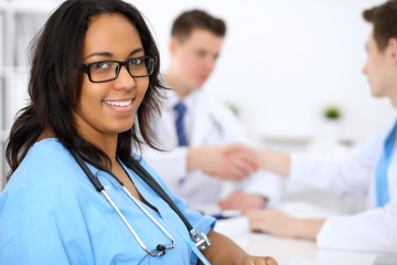 Female african american medical doctor with colleagues in background