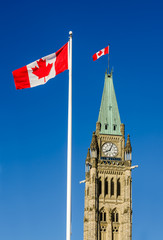 Fototapeta na wymiar Close up of peace tower (parliament building) in Ottawa, Canada, with canadian flags