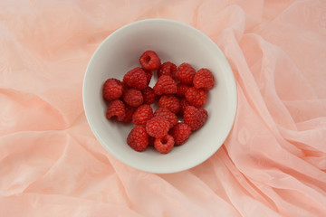 Red raspberries in white bowl