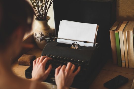 Young woman using typewriter